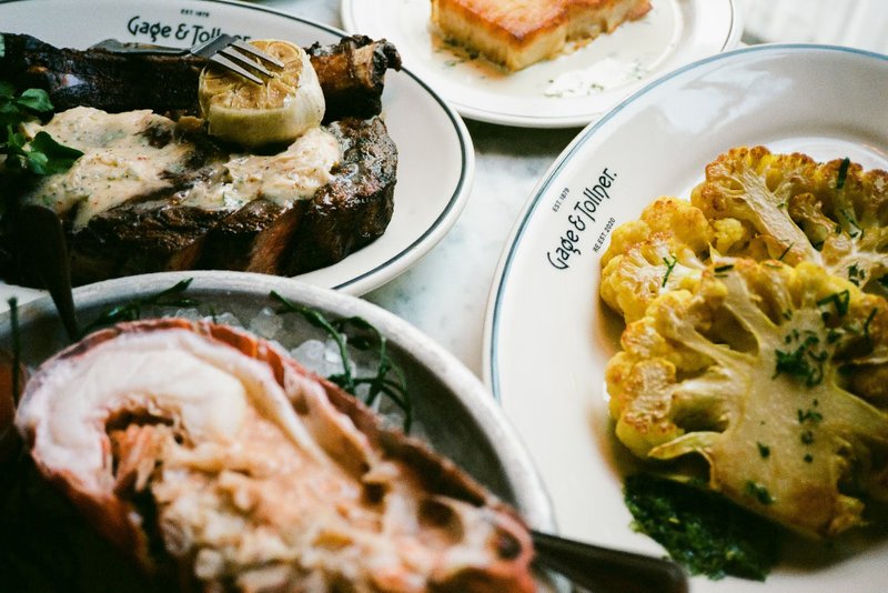 A variety of food on plates with the logo Gage & Tollner