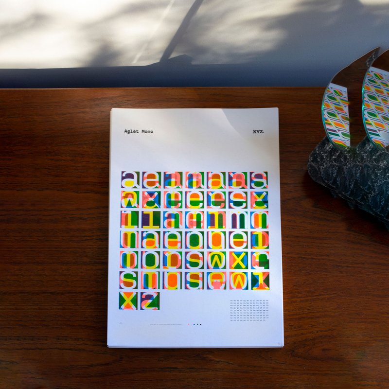 A colorful art print rests on a wooden table.