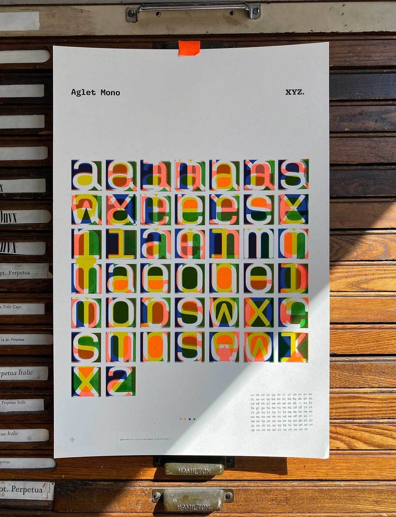A colorful art print is taped to the front of a type case cabinet.