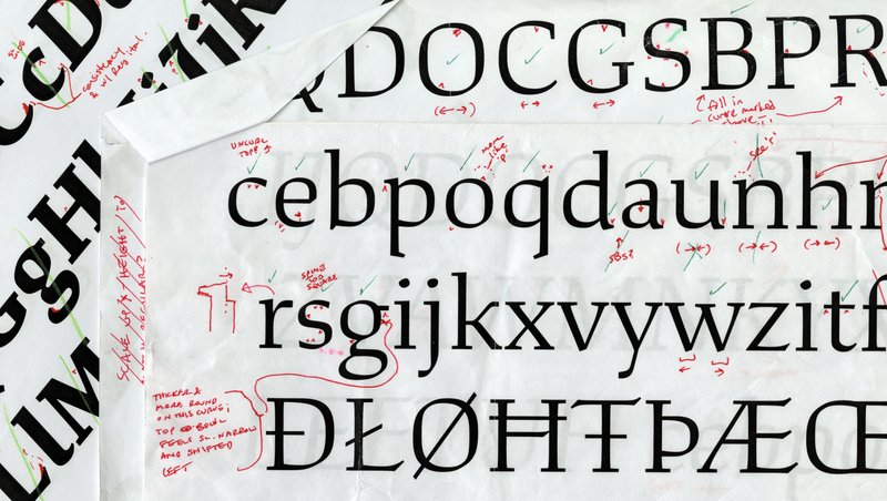 A stack of font proof printouts with red markings