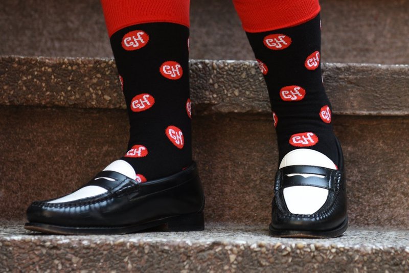Close up feet wearing of a pair of socks with the CH monogram woven into them